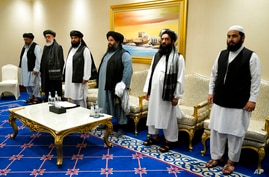 FILE - In this Nov. 21, 2020 file photo, members of the Taliban's peace negotiation team meet with Secretary of State Mike…