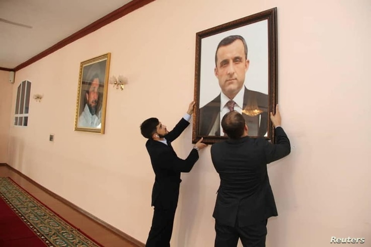 Afghan embassy staff hang a portrait of Afghan First Vice President Amrullah Saleh, who declared himself the "legitimate…