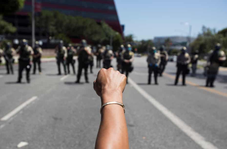 A participant raises a fist against police officers during a Black Lives Matter march in Los Angeles on 14 June 2020.