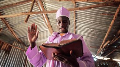 A worshipper of Adundo Messiah church reads the Bible during the Sunday church service in Kisumu, Kenya