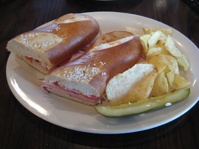 Corner Bakery's Bavarian Ham on Pretzel Bread with chips and pickle spear