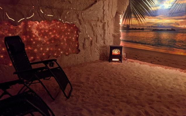 A salt cave at Bella Vita in downtown St. Cloud features Himalayan salt on the floors and walls, a calming beach scene and small salt particles disper