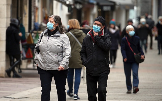 People wearing faces masks to protect against coronavirus walk along the main street in Saint jean de Luz, southwestern France, Monday, Nov.29, 2021. 