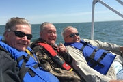 (Above) Paul Bower, flanked by Jim Tuller, left,  and James Powers mark their calendars to hit the lake on the Saturday after the state fishing opener
