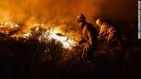 Firefighters operate at the site of a wildfire between Navalacruz and Riofrio near Avila, central Spain, on August 16, 2021. - A thousand people were evacuated and more than 5,000 hectares burned from 11am, with flames spreading up over a 40-kilometer perimeter. Spain saw its highest temperature on record on Saturday as a heatwave on the Iberian peninsula drove the mercury to 47.4 degrees Celsius (117.3 Fahrenheit), according to provisional data from the state meteorological agency. (Photo by CESAR MANSO / AFP) (Photo by CESAR MANSO/AFP via Getty Images)