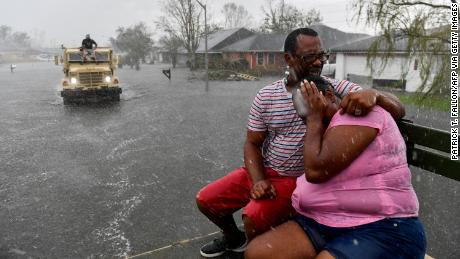 TOPSHOT - People react as a sudden rain shower soaks them with water while riding out of a flooded neighborhood in a volunteer high water truck assisting people evacuating from homes after neighborhoods flooded in LaPlace, Louisiana on August 30, 2021 in the aftermath of Hurricane Ida. - Rescuers on Monday combed through the &quot;catastrophic&quot; damage Hurricane Ida did to Louisiana, a day after the fierce storm killed at least two people, stranded others in rising floodwaters and sheared the roofs off homes. (Photo by Patrick T. FALLON / AFP) (Photo by PATRICK T. FALLON/AFP via Getty Images)