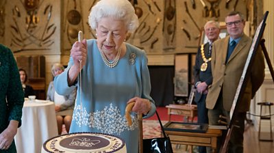 The Queen cuts her cake at a reception for her Platinum Jubilee