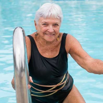 Older woman getting out of swimming pool