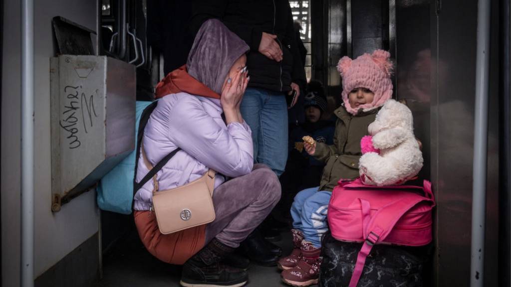 People board a train to leave the country at the railway station of the western Ukrainian city of Lviv on March 7, 2022, as Russian attacks continue