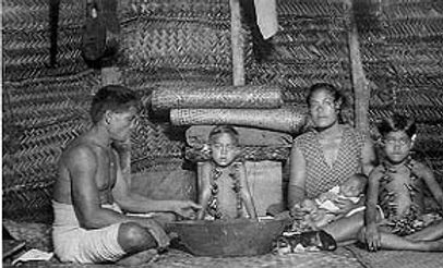 America Samoa family insde a family fale wit woode serving bowl and lowered blinds (pola). Circa 1940