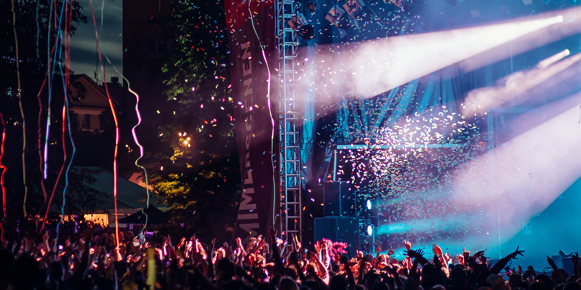 Publikhav med konfetti som flyger i luften framför stor sen på festival. Fotograf: Avig Photo