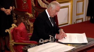 King Charles III signing papers
