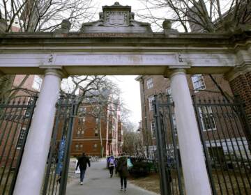 FILE - In this Dec. 13, 2018, file photo, a gate opens to the Harvard University campus in Cambridge, Mass. Harvard President Lawrence Bacow announced Tuesday, April 26, 2022 that the university is committing $100 million to study its ties to slavery and create a 