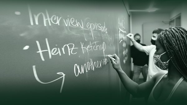 student writing script elements on a chalkboard