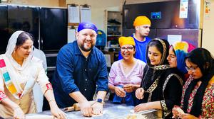 Alex Meehan making chapatis alongside the women in Dublin's Sikh temple kitchen, including Harjinder Kaur, Manpreet Kaur, Dilnaaz Kaur and Jasleen Kaur. Photo: Kyle Tunney