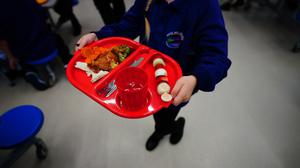 A student carries a lunch tray in a school canteen. Photo: PA