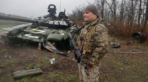 A Ukrainian service member stands next to a damaged Russian tank T-72 BV last April. Picture by Serhii Nuzhnenko