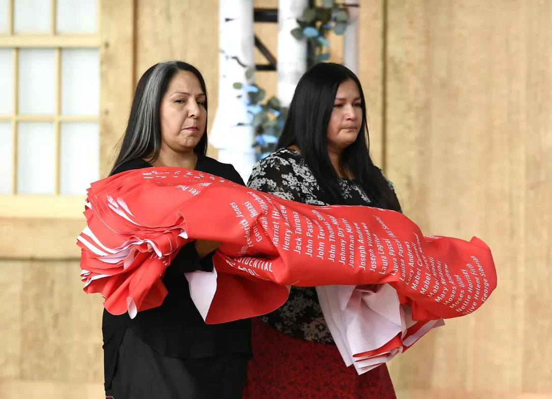 Joyce Hunter, right, whose brother Charlie Hunter died at St. Anne’s Residential School in 1974, and Stephanie Scott, a staff member at the National Centre for Truth and Reconciliation, carry a ceremonial cloth with the names of 2,800 children who died in residential schools during a ceremony on the National Day for Truth and Reconciliation in Gatineau, Que., Monday, Sept. 30, 2019.
