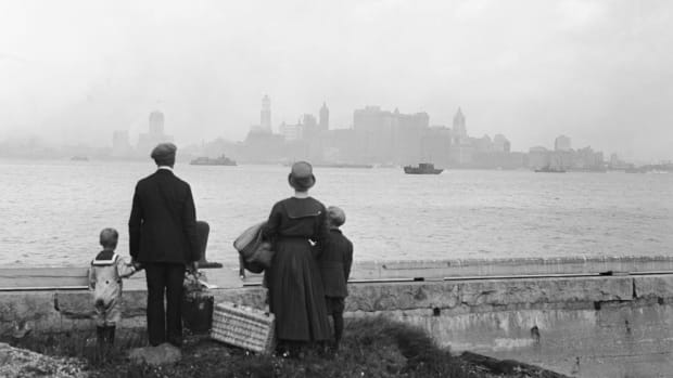 An immigrant family on the dock at Ellis Island, c. 1925. (Credit: Bettmann/Getty Images)