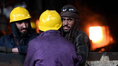 Labourers take a break at a steel mill at an industrial area in Islamabad on February 9, 2023.