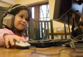 Child using a computer with headphones