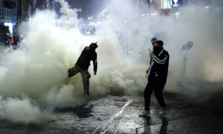 A protester throws back a canister with teargas during a protest against a bill on foreign influence transparency in Tbilisi, Georgia on Wednesday