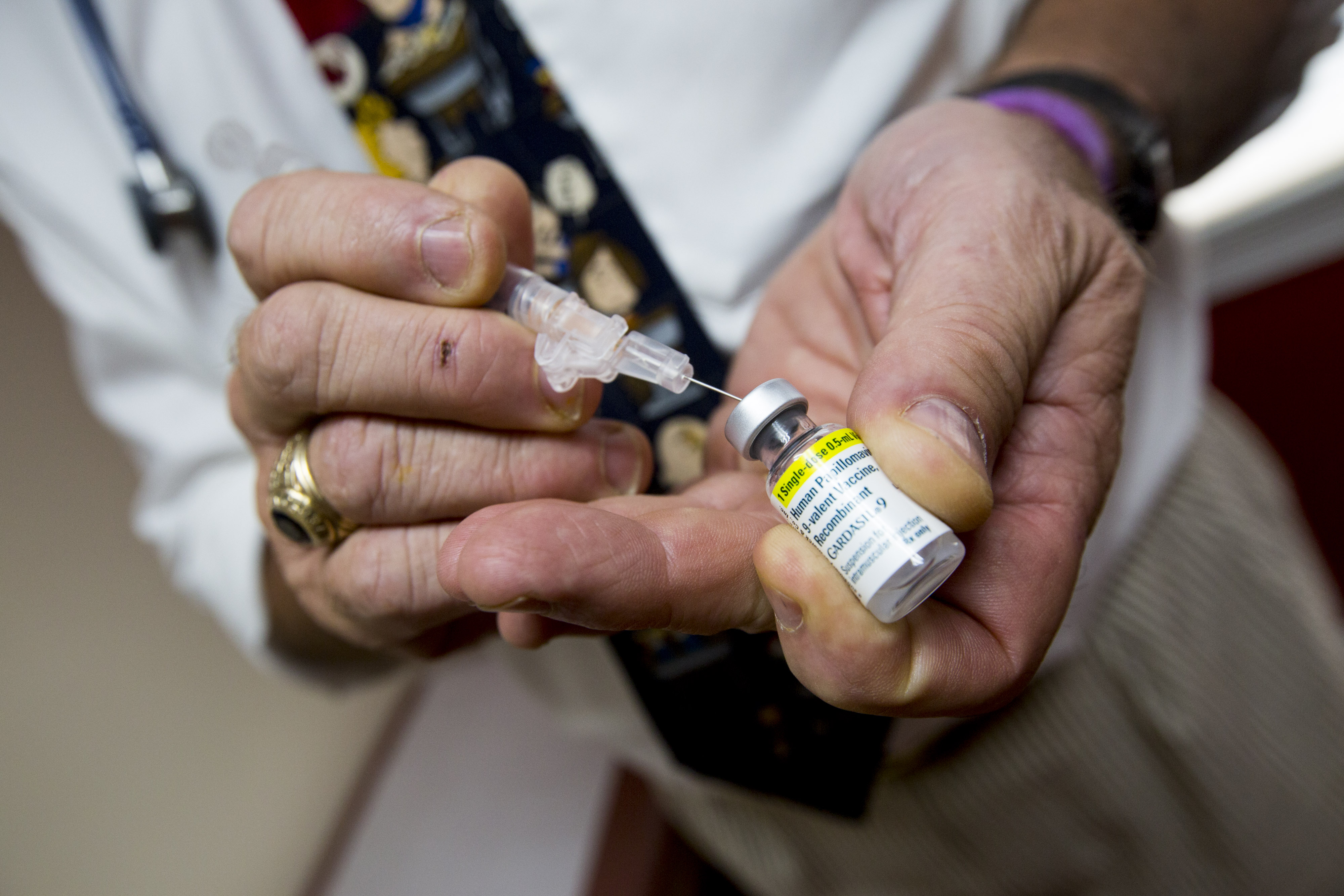 The HPV vaccine is drawn from a small vial into a syringe. 