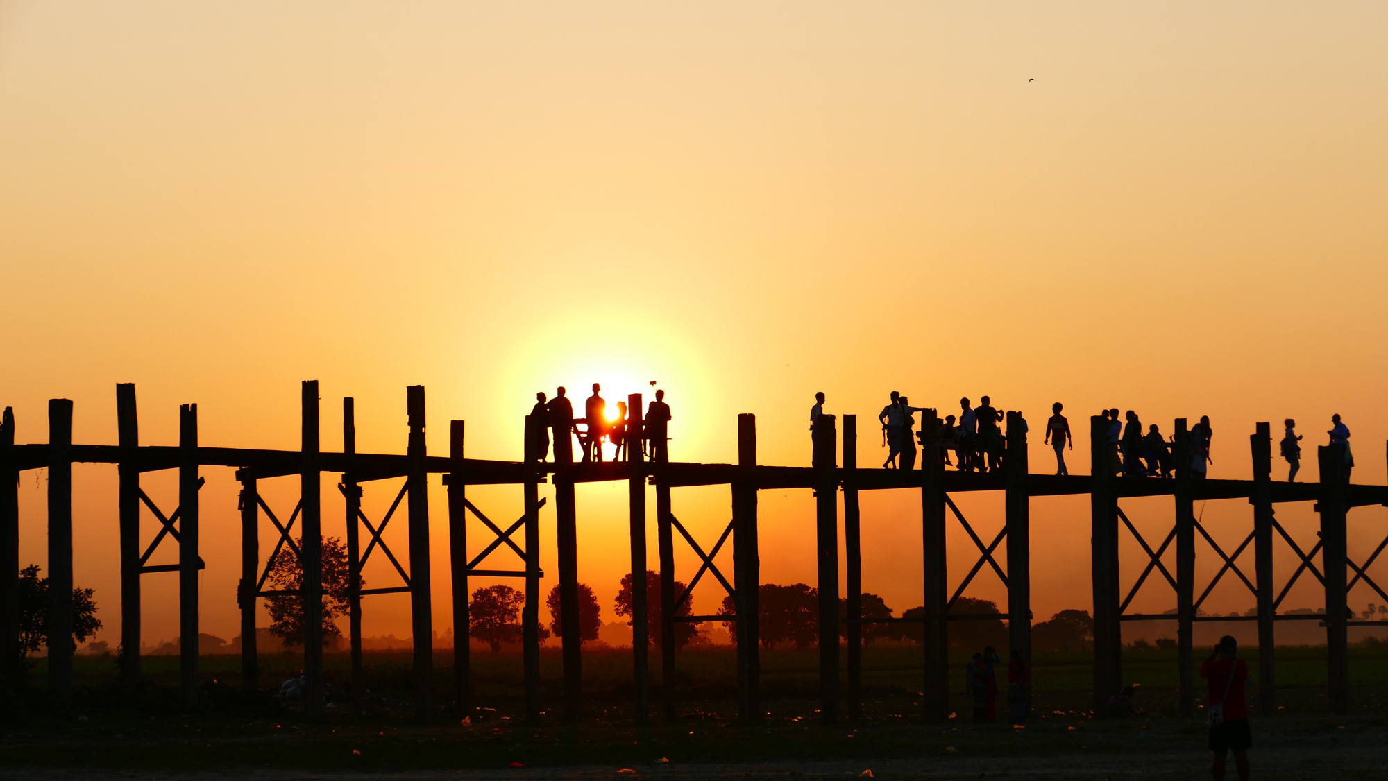 Group of people on a bridge at sunset