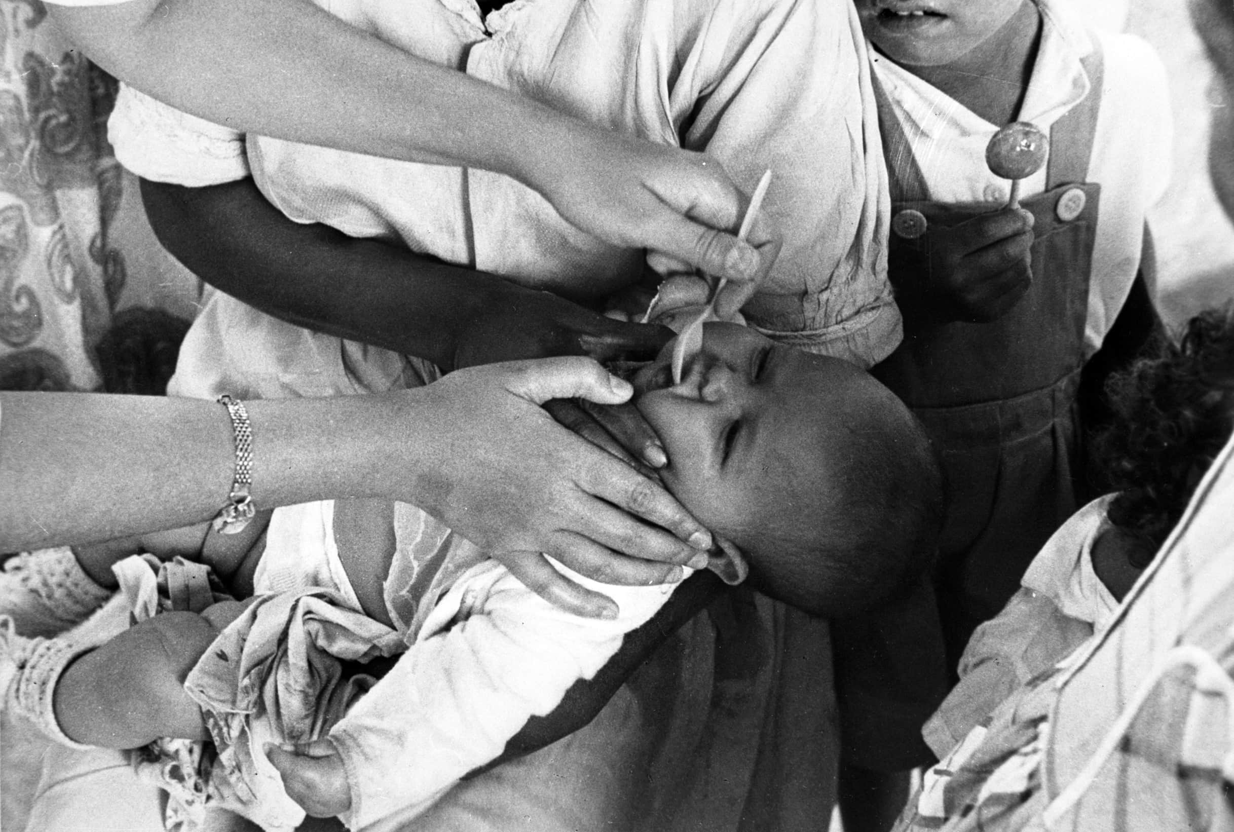 Colombia 1958: the live poliovirus syrup vaccine being administrated to a young child