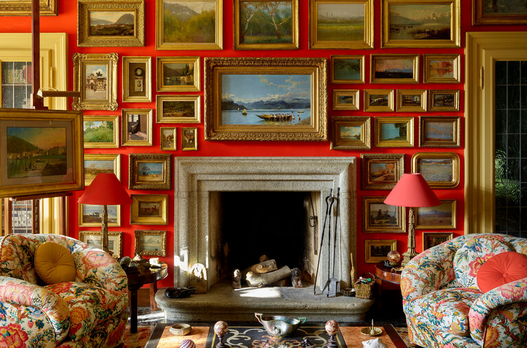 In the main salon of Giorgio Taroni’s home on Italy’s Lake Como, part of his collection of 19th-century paintings, chairs and a sofa upholstered in a fabric designed by Taroni Disegni in the 1970s and a 17th-century scagliola table.