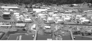 Picture of large tanks for storing petro-chemicals along the Willamette River with docs for loading and off loading petro chemicals in the fore ground.