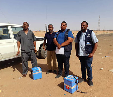 Dr Thabit (extreme right) and Hatim Babiker (second from left) handing over stool samples to the focal points from Egypt, at the Argeen border crossing point