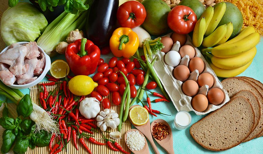 Una foto de diferentes tipos de alimentos en los cinco grupos de alimentos: verduras, frutas, productos lácteos, aceites y proteínas.