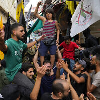 People dance in celebration of the attacks that the Hamas terror group carried out against Israel, at Bourj al-Barajneh Palestinian refugee camp, in Beirut, Lebanon, October 7, 2023. (AP Photo/Bilal Hussein)