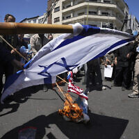 Iranian demonstrators burn representations of the Israeli and the US flags in their rally to mark Jerusalem Day, an annual show of support for the Palestinians, in Tehran, Iran, Friday, April 14, 2023. (AP/Vahid Salemi)