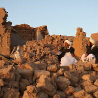 Afghan residents sit at a damaged house after earthquake in Sarbuland village of Zendeh Jan, district of Herat province, on October 7,2023 (Mohsen KARIMI / AFP)