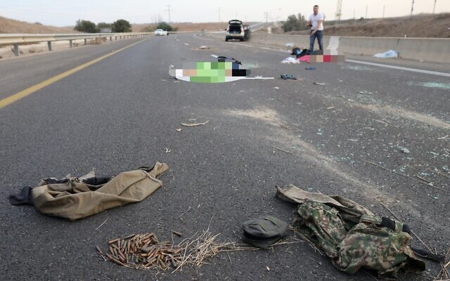 Bodies lie on a main road near Kibbutz Gevim on October 7, 2023 following an attack by Hamas terrorists. (Oren ZIV / AFP)