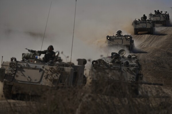 Israeli APC head towards the Gaza Strip border in southern Israel on Friday, Oct.13, 2023. (AP Photo/Ariel Schalit)