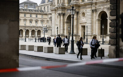Staff leave the Louvre Museum as people are evacuated after it received a written threat, in Paris, Saturday Oct. 14, 2023. (Thomas Padilla/AP)