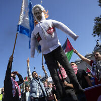 Protesters chant slogans while burning a doll with a picture of Prime Minister Benjamin Netanyahu, and a mock of an Israeli flag during a protest to show their solidarity with the Palestinians, in Istanbul, Turkey, October 20, 2023, amid the ongoing war between Israel and the Gaza-ruling Hamas terror group. (AP Photo/Khalil Hamra)