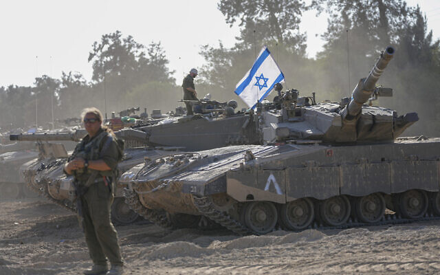 Israeli soldiers work on a tank at a staging area near the border with the Gaza Strip, in southern Israel Friday, Oct. 20, 2023. (AP Photo/Ohad Zwigenberg)