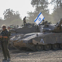 Israeli soldiers work on a tank at a staging area near the border with the Gaza Strip, in southern Israel Friday, Oct. 20, 2023. (AP Photo/Ohad Zwigenberg)