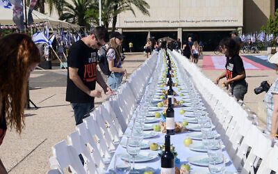 Families of Israelis held hostage by Hamas terrorists in Gaza set a symbolic Shabbat table with more than 200 empty seats for the hostages, at 'Hostage Square,' outside the Art Museum of Tel Aviv, October 20, 2023. (Avshalom Sassoni/Flash90)