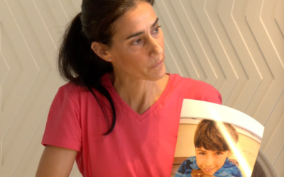 Bat-Sheva Yahalomi, holding a photo of her 12-year-old son, Eitan, who she believes was taken captive into Gaza on October 7, 2023 (Courtesy)
