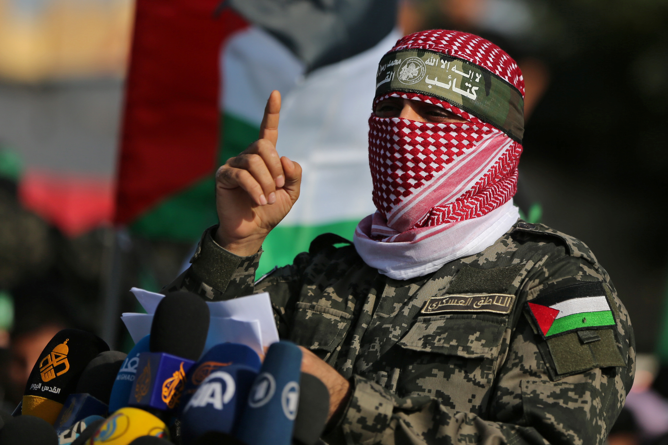 Abu Ubaida, the spokesman of the Izz el-Deen al-Qassam Brigades, gestures as he speaks during an anti-Israel military show in the southern Gaza Strip