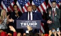 Donald Trump standing behind a 'Trump make America great again sign'