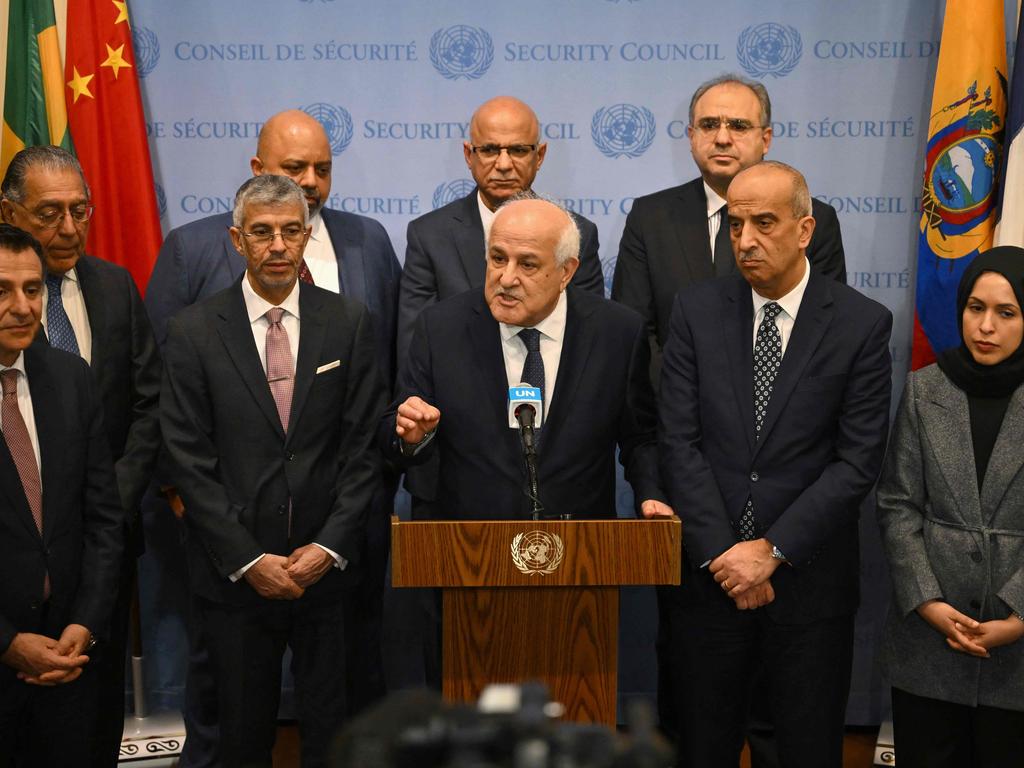 Palestinian Ambassador to the United Nations Riyad Mansour, flanked by representatives of Arab countries, speaks to the press after a UN General Assembly meeting to vote on a non-binding resolution demanding "an immediate humanitarian ceasefire" in Gaza at UN headquarters in New York on December 12, 2023. (Photo by ANGELA WEISS / AFP)