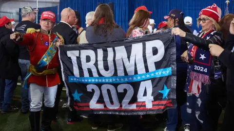 Supporters hold a Trump 2024 sign