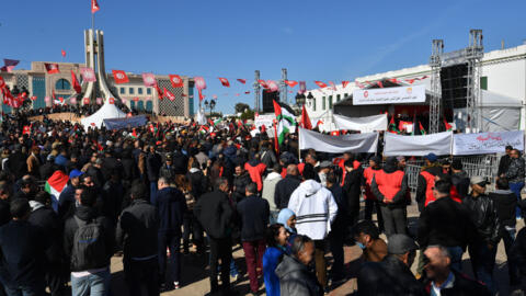 Trade unionists raise national flags and placards in Tunis, Tunisia to protest against a proposed legislation that will grant the government sweeping powers over NGOs, March 2, 2024. 