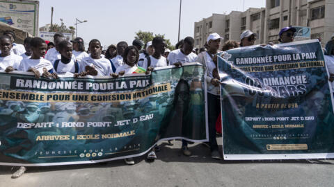Supporters of the President of Senegal Macky Sall and presidential candidate Amadou Ba carry banners during a march for peace in Dakar on March 3, 2024.